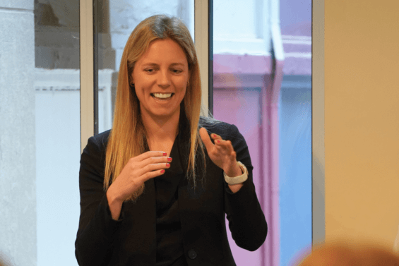 Brittany Borsanyi presenting to a crowd in large office building.