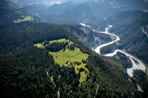 Overhead shot of green trees and winding river in Switzerland