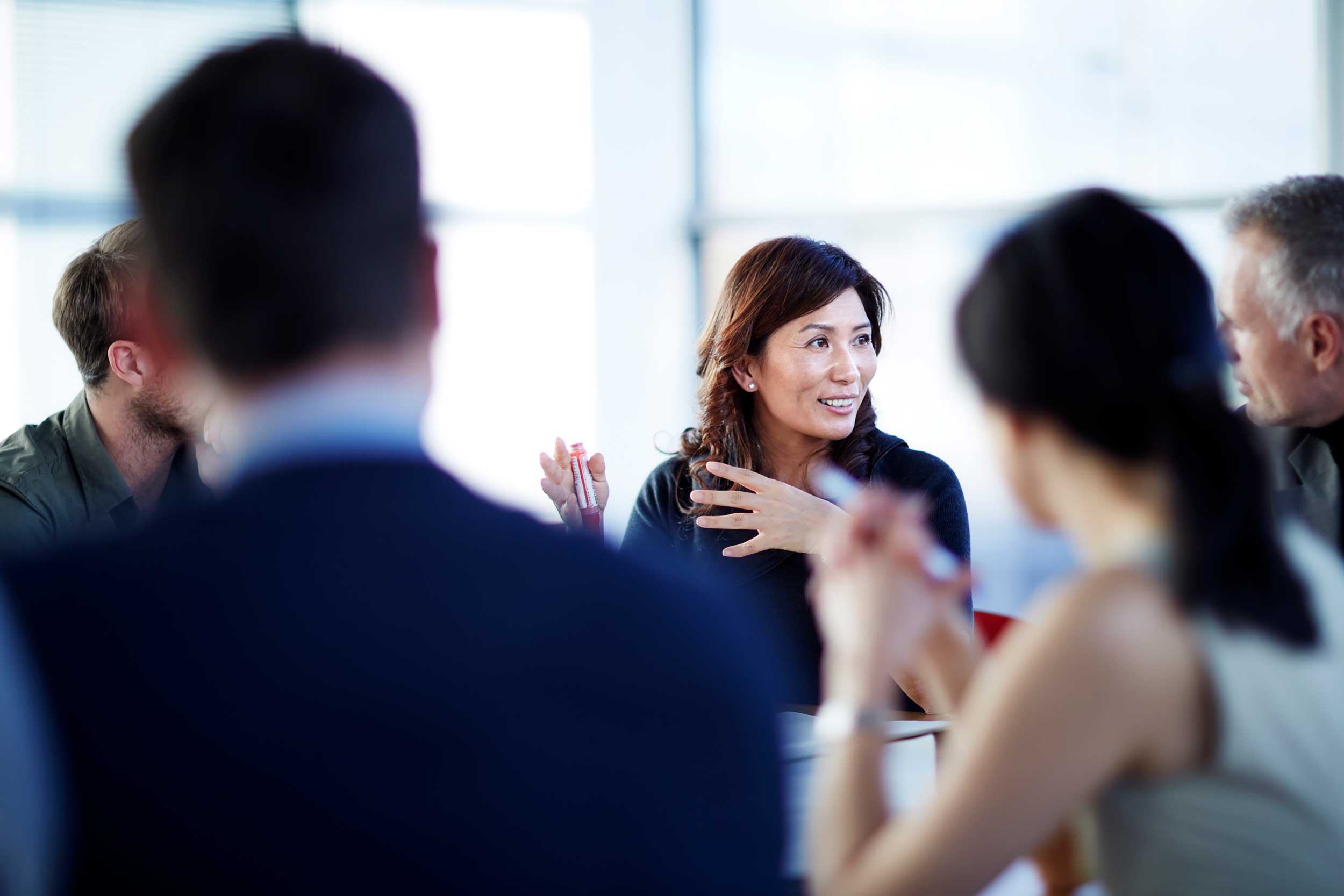 Business woman speaks in meeting with colleagues