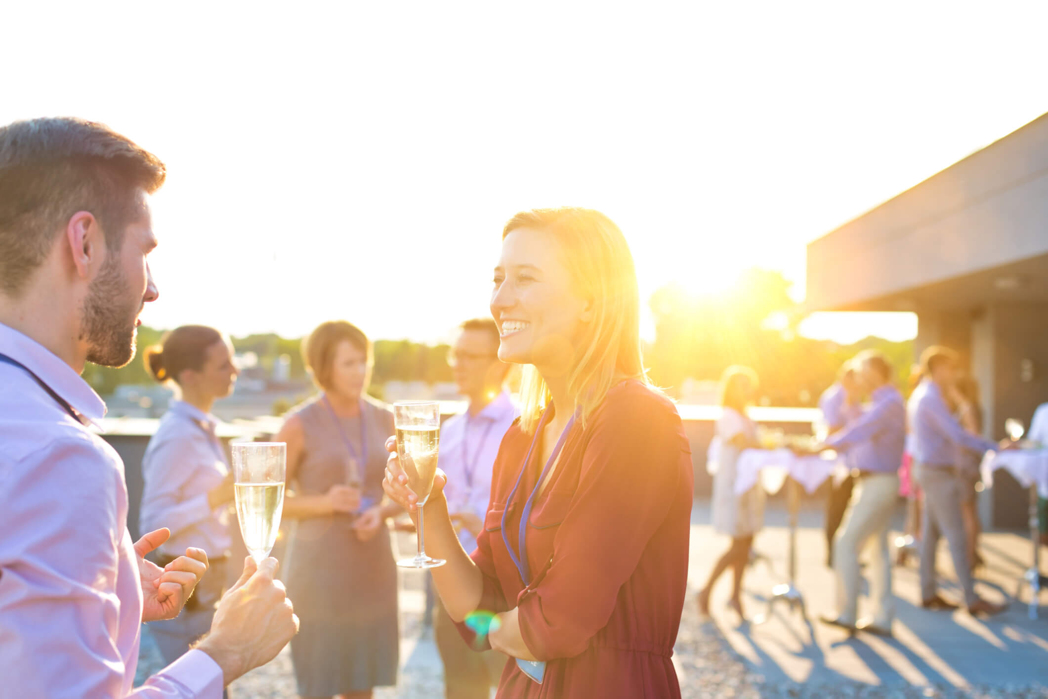 Smiling business colleagues standing at table during rooftop party