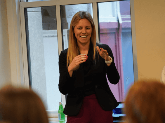 Birttany Borsanyi presenting to a crowd in an office building