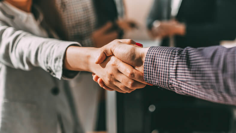 close up of young casual business people shaking hands with each other.
