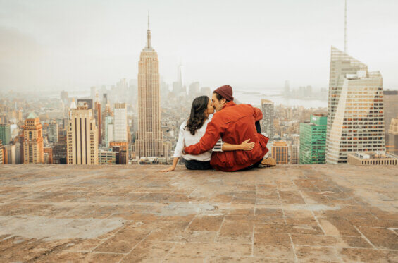 Young couple kissing on a rooftop after a relocation to New York City.