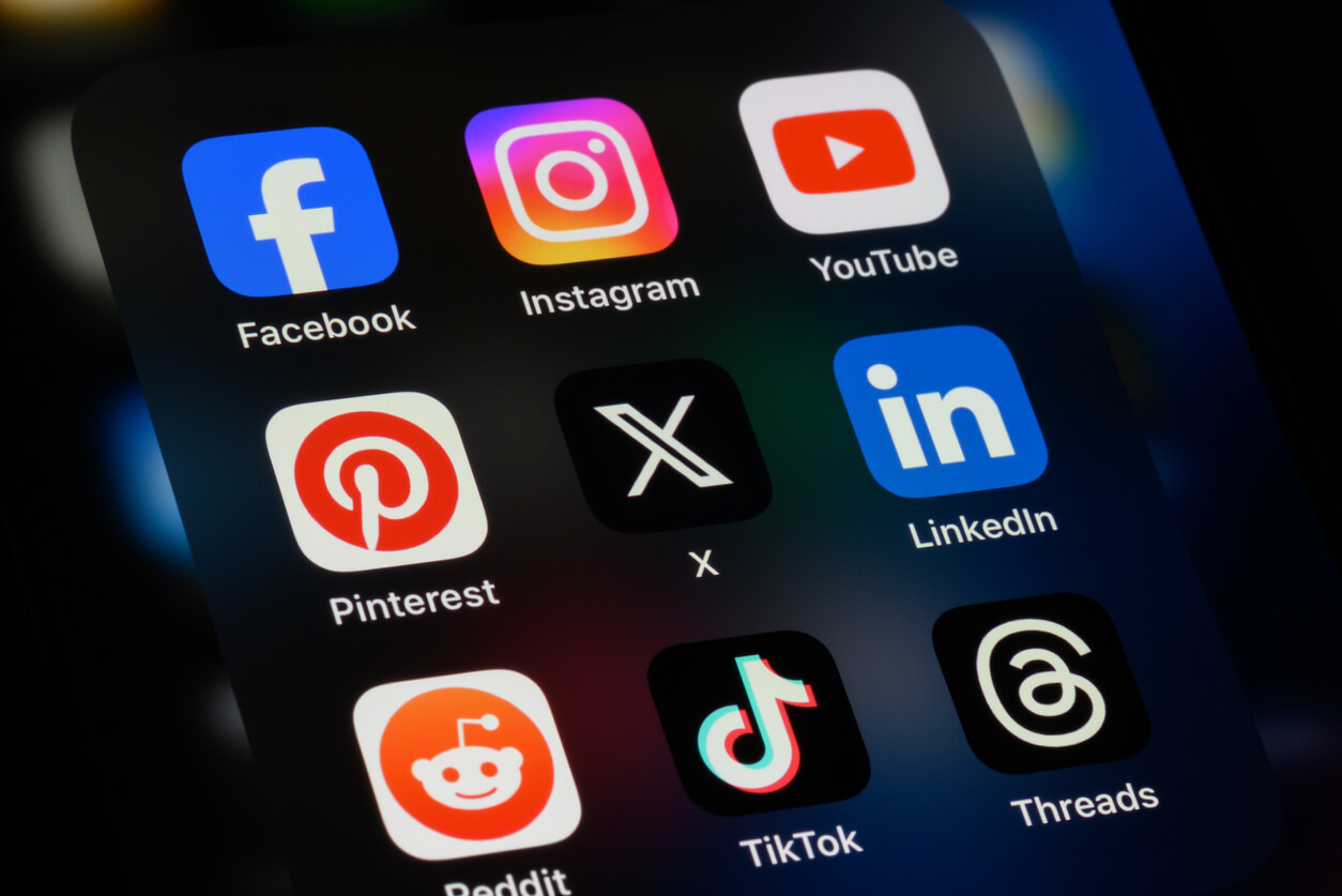 Popular social media apps on an Apple iPhone: Facebook, Instagram, YouTube, Pinterest, X (formerly Twitter), LinkedIn, Reddit, TikTok, and Threads.