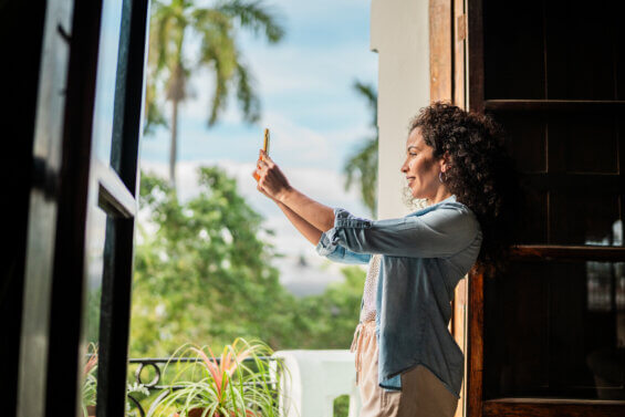An influencer taking photos on a hotel balcony to encourage hotel direct bookings