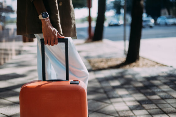 Orange suitcase being pushed down a street - National Travel and Tourism Week 2025