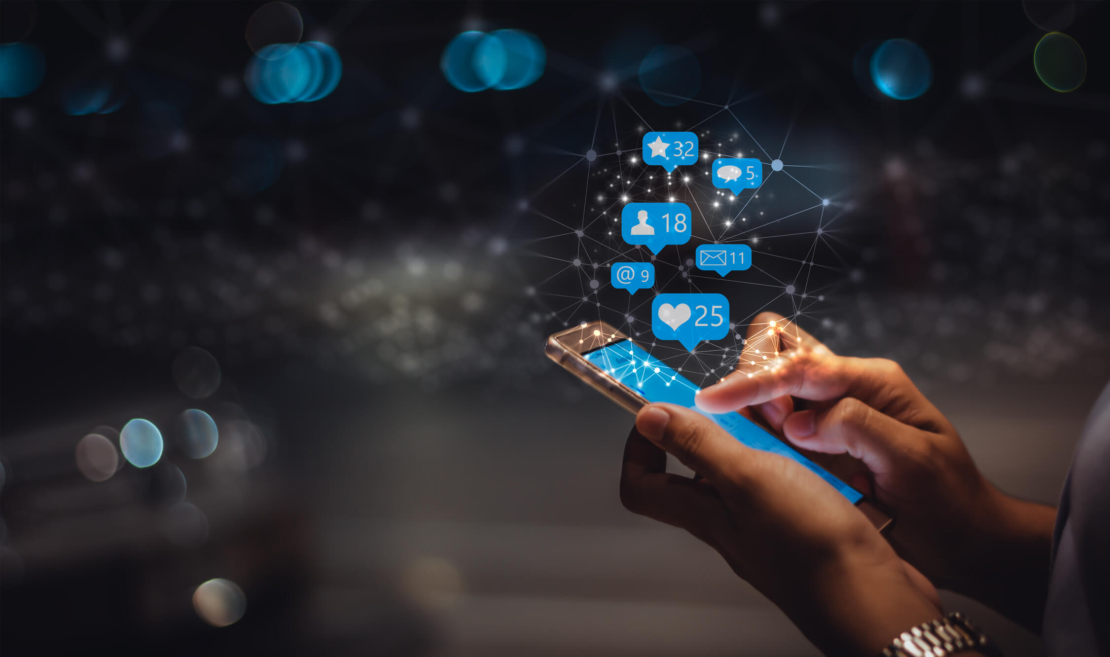 A hand holding a phone that is displaying activity such as likes and shares from advertising on LinkedIn