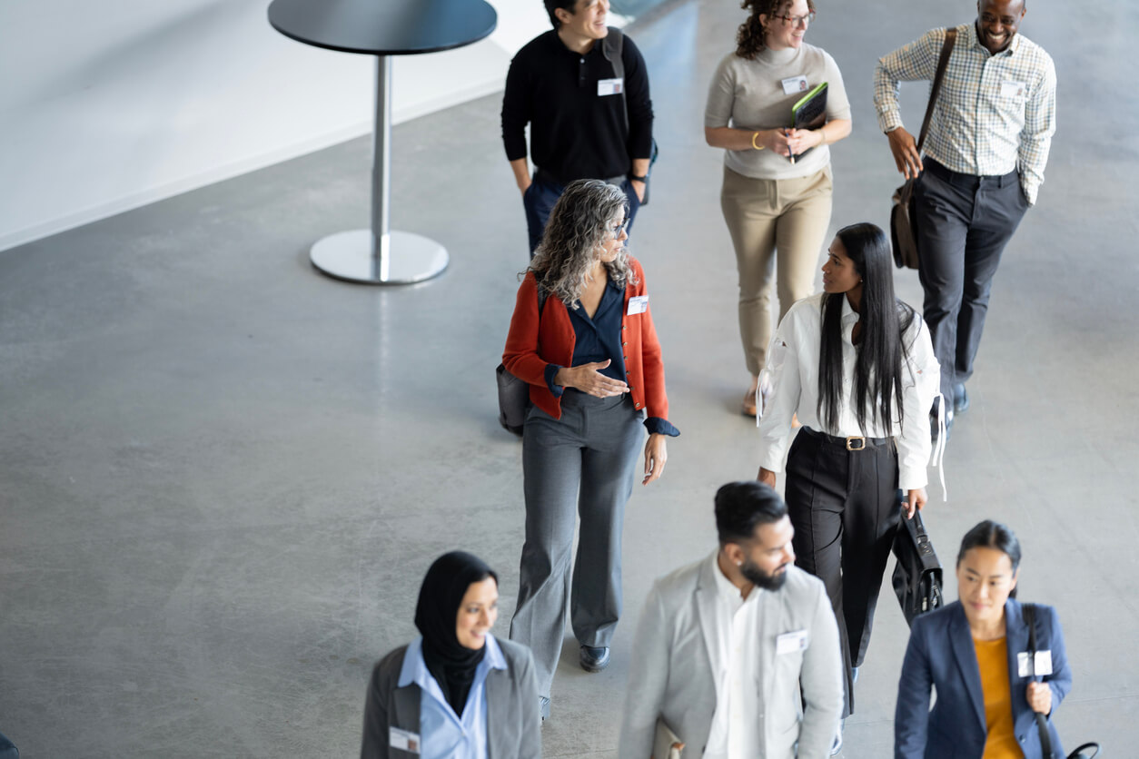 Diverse group of people walking into an in-person travel trade show