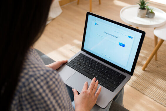 Person typing on a laptop, using an artificial intelligence chatbot application
