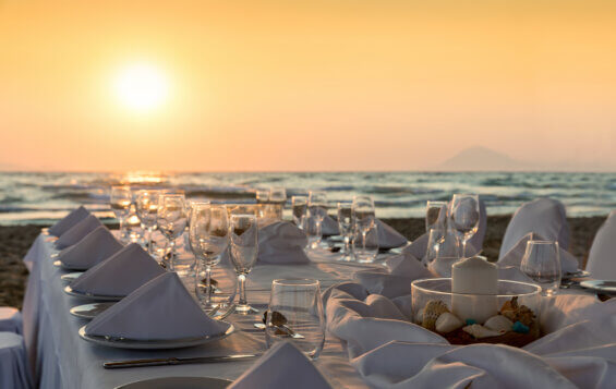 Beautiful dinner event set up on a Grecian beach at sunset