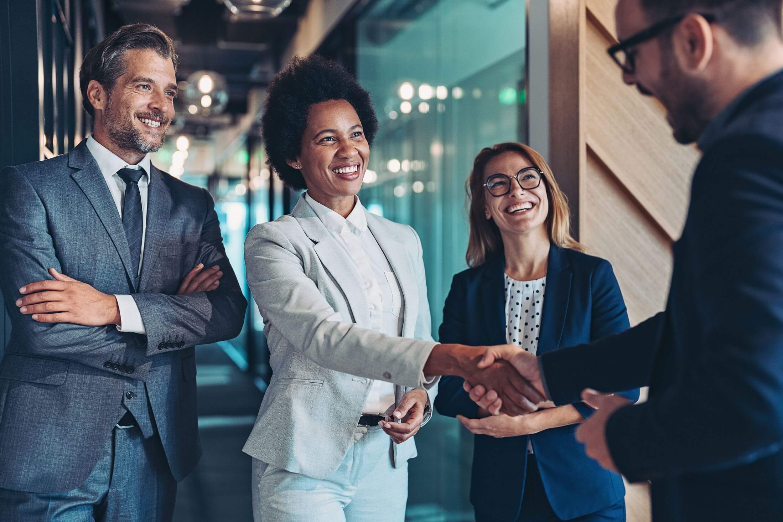 a group of business people smiling while shaking hands