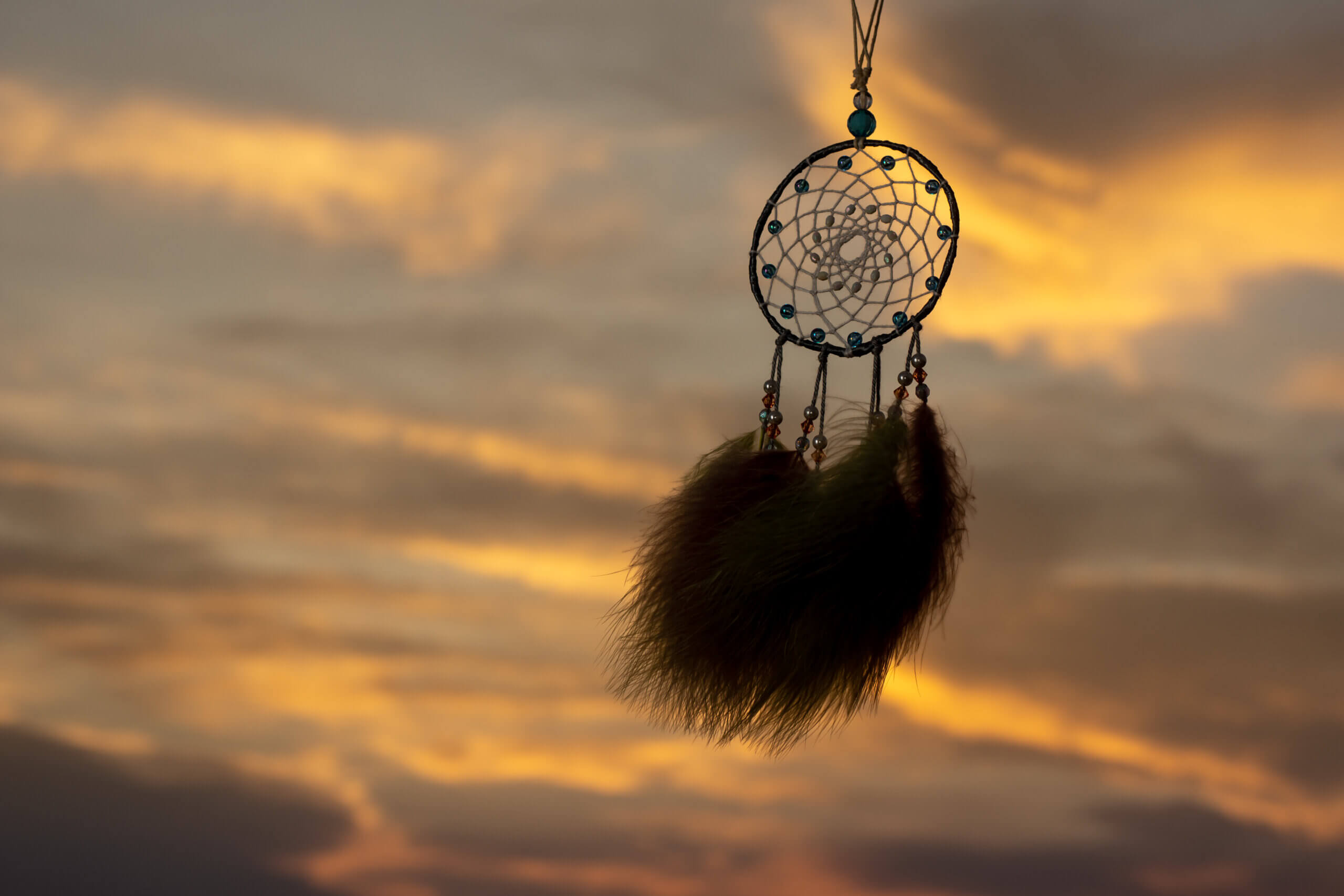 Silhouette of handicraft dream catcher against the breeze and dusk sky